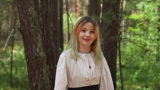 blonde girl smiles in medieval forest, close-up