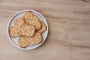 square salty diet crackers with black cumin seeds and quinoa in a glass plate