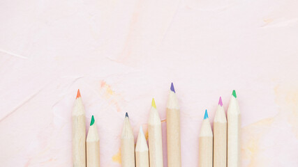 Multicolored pencils on pink background