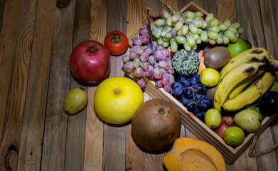 Basket of organic fruits on wooden banner background - fresh eating concept