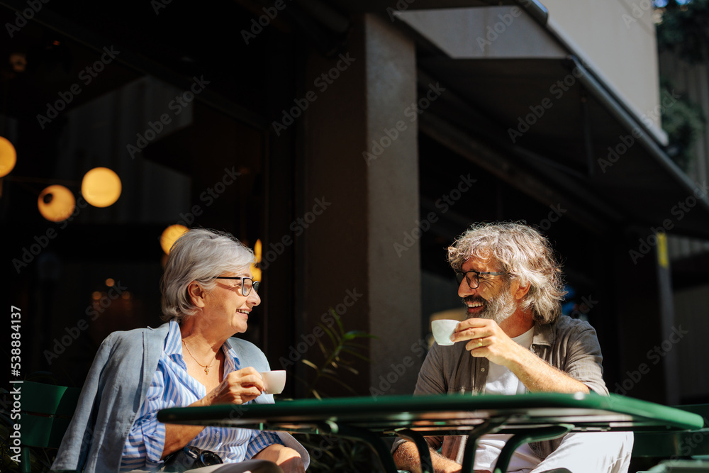 Wall mural senior couple having coffee outside.