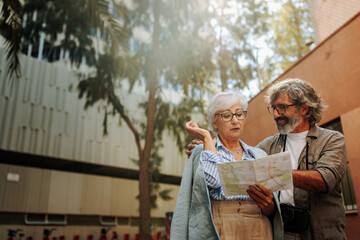 Naklejka premium Senior tourists checking map in city.