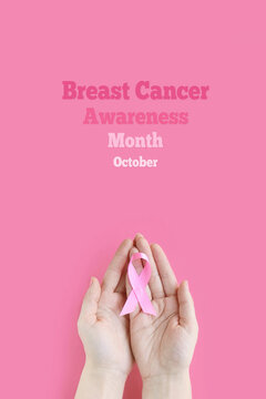 Breast Cancer Awareness Month. Adult holding pink ribbon on black background. International symbol of Breast Cancer in October. Healthcare and medicine