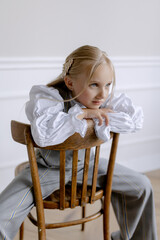 Fototapeta na wymiar European appearance of the child. Sitting on a chair and posing