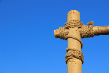 Tied neatly with twine of brown hemp rope to several large pieces of bamboo. The background is a bright blue sky.
