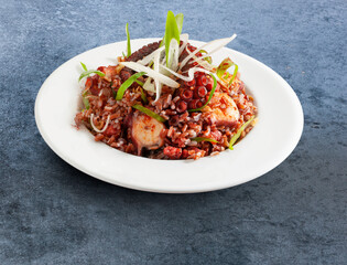 Ensalada de pulpo con verduras sobre fondo azul. Octopus salad with vegetables on a blue background.