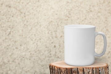 Blank ceramic cup on wooden podium