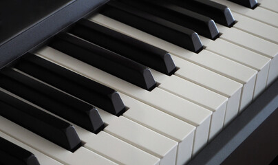 Close up of the white and black keys on an electronic piano. Diagonal view of piano keys.