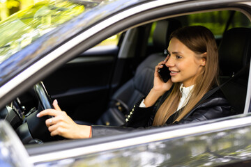 Portrait of driver talking her mobile phone while driving car.