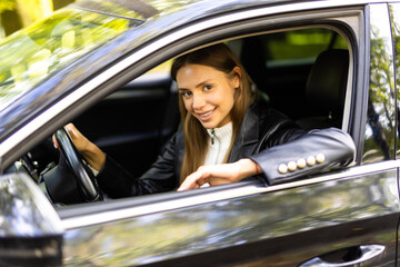 Confident and beautiful. Attractive young woman in casual wear looking over her shoulder while driving a car