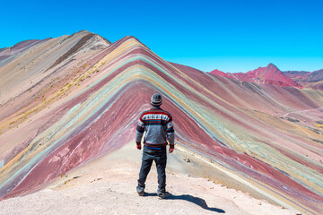 een man kijkt naar Vinicunca Rainbow Mountains, Peru