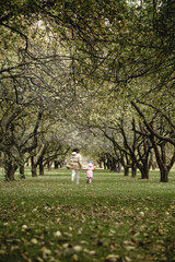 Naklejka premium mother and daughter run in the autumn park