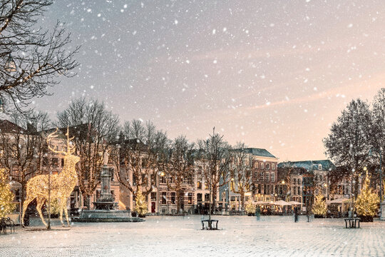 Winter view with snowfall of the central historic square with bars and restaurants in the ancient city center of Deventer, The Netherlands