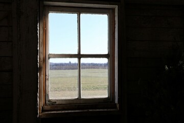 Vielle fenêtre dans une grange donnant sur un champ pendant l'hiver