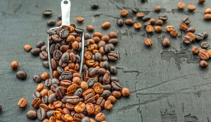 Blended roasted coffee beans or mixed coffee beans on a black background.