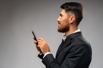 Young businessman using mobile phone in studio
