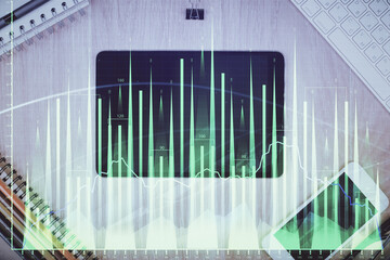 Double exposure of forex graph hologram over desktop with phone. Top view. Mobile trade platform...