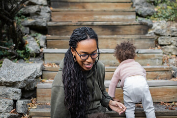 Black mom smiling with son on stairs outside in fall/autumn