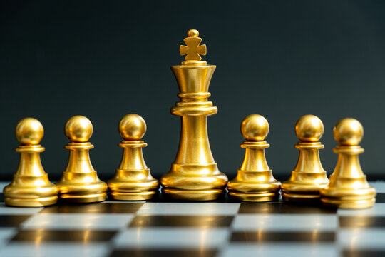 Gold king chess piece stand with pawn on black background (Concept of teamwork, management)