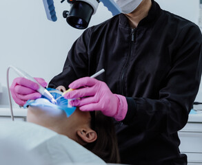 Las manos de dentista en tratamiento odontologico en consultorio odontologico.