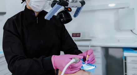 Las manos de dentista en procedimiento odontologico en clinica odontologica.