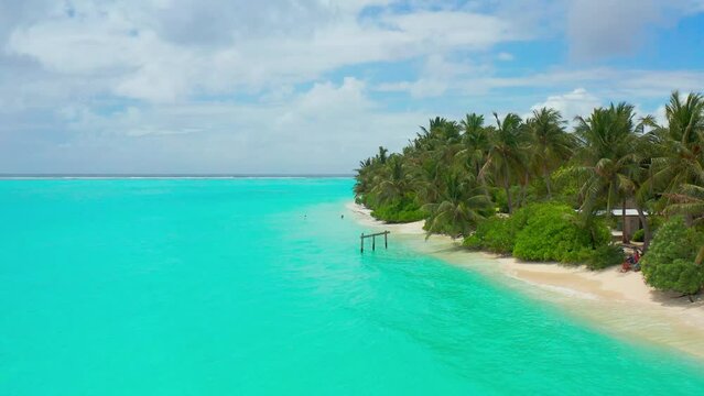 Aerial view on Bikini white sand beach with turquoise waters and palms on Maldives island Thoddoo.