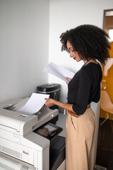 Dark-haired well-dressed woman making xerocopies