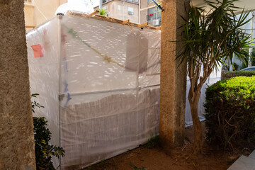 Jewish festival of Sukkot in Israel. Traditional sukkah with handmade decorations near the building on the street. 