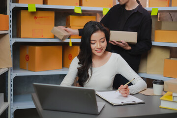 Asian Start-up businesswoman writing an order from online delivery. Freelancer is checking...