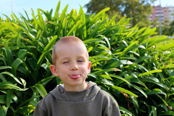 The short-haired, blond boy closed his eyes and stuck his tongue out. A carefree five-year-old boy. 