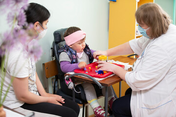 A psychologist works with a small child with mental retardation.