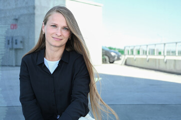 Close up portrait of smilling 35 years old woman with long natural hair. Flying blonde hair on the wind. Vertical photo