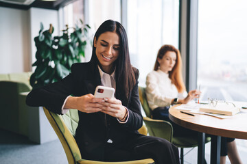 Smiling businesswoman using smartphone at office