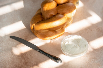 Challah Shabbat braided bread with silver knife and cottage cheese. Traditional Meal for Jewish cuisine Friday or Saturday dinner. 