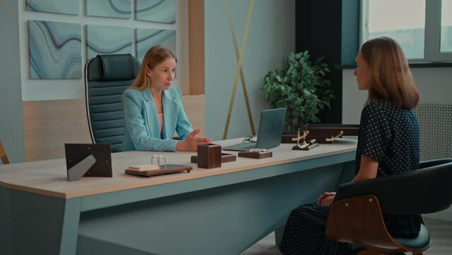 female recruiter talking to candidate job interview employer talking with employee two woman talking sitting at a desk