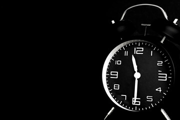 Time concept. black alarm clock in dark background with copy space.
