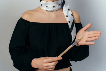 elegant woman holding a spotted painting brush on white background. High quality photo