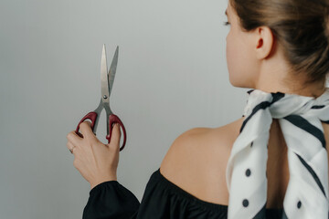 young woman holding scissors on white background. High quality photo