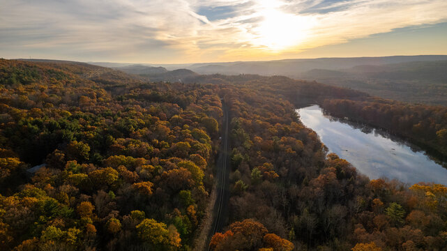 Aerial View of River Winding Through Autumn Forest Valey at Golden Hour