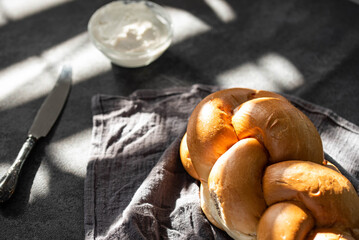 Challah Shabbat braided bread with silver knife and cottage cheese. Traditional Meal for Jewish cuisine Friday or Saturday dinner. 