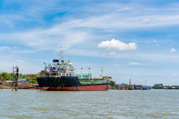 Fototapeta premium Cargo freight ship moored at import and export port to load industrial goods