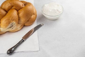 Challah Shabbat braided bread with silver knife and cottage cheese. Traditional Meal for Jewish cuisine Friday or Saturday dinner. 