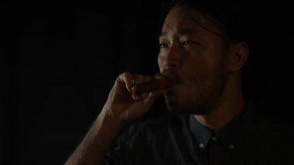 Night club concept of 4k Resolution. Asian man smoking cigar in restaurant. A group of specialized clubs that sell alcoholic beverages.