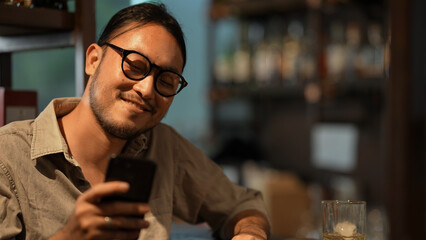 Night club concept of 4k Resolution. An Asian male customer is drinking alcohol in a liquor store. A group of specialized clubs that sell alcoholic beverages.
