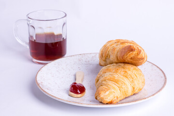 café, croissant com geleia no  prato  em fundo cinza