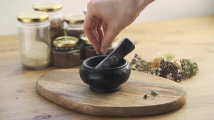 Slow motion shot of herb grinding with granite mortar and pestle