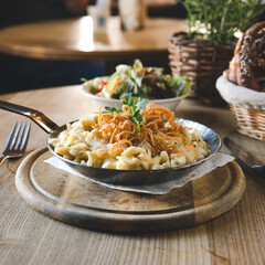 Käsespätzle mit Röstzwiebeln quadratisches close-up Foto