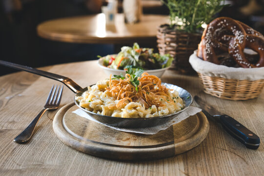 K&auml;sesp&auml;tzle mit R&ouml;stzwiebeln in einer eiserner Gusspfanne