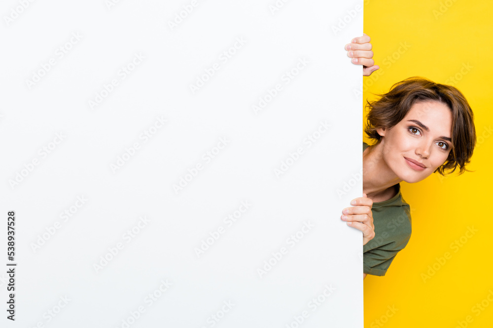 Sticker Photo of pretty cute sweet lady dressed stylish clothes hand hold empty space head look out big wall isolated on yellow color background