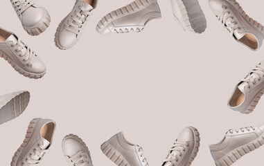 Frame from Beige gray leather female sneakers with lace isolated on beige background. Flying fashion stylish casual sneakers, sports unisex clothing shoes. Advertising Minimal mockup with footwear